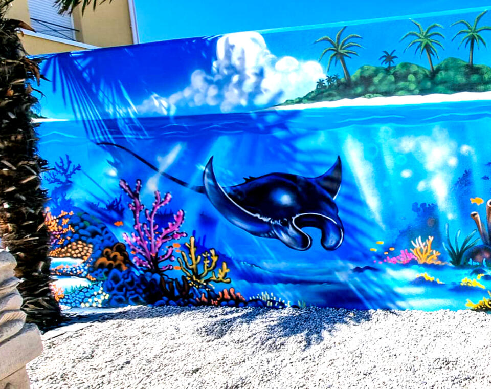 Décoration street-art graffiti d'un fond marin sur le mur extérieur d'un jardin à Châtelaillon