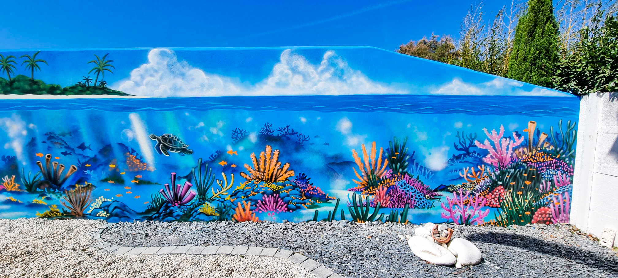 Décoration street-art graffiti d'un fond marin sur le mur extérieur d'un jardin à Châtelaillon