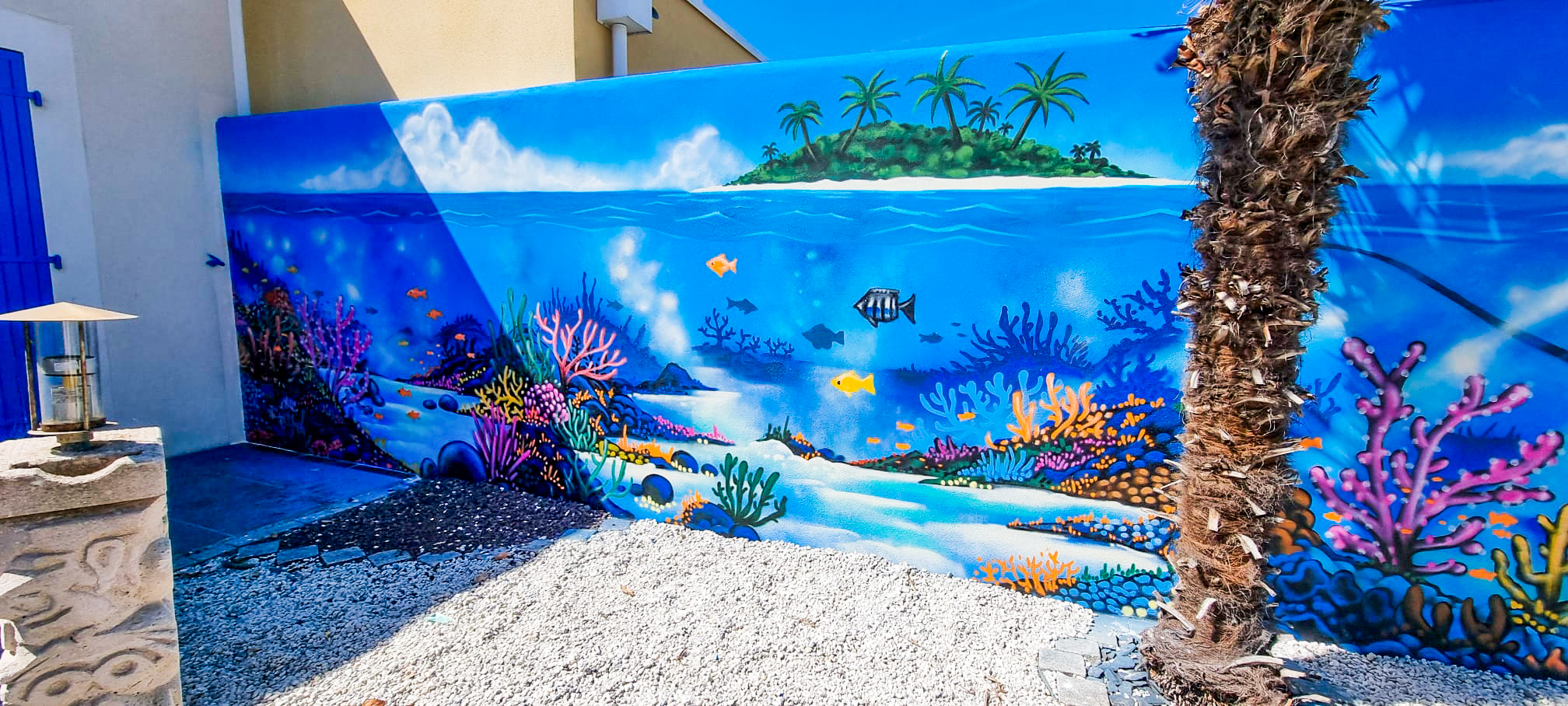 Décoration street-art graffiti d'un fond marin sur le mur extérieur d'un jardin à Châtelaillon